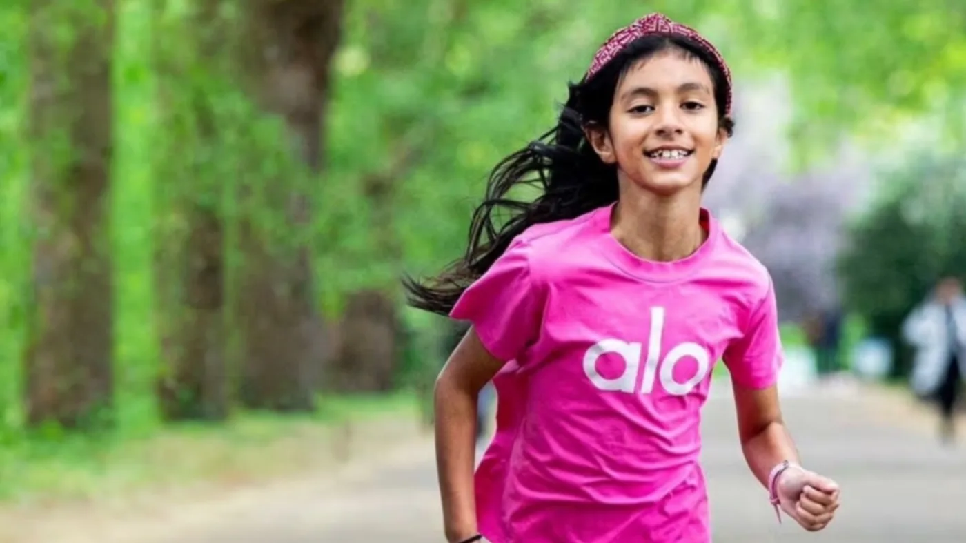 Lily Janmohamed running on a tree-lined path